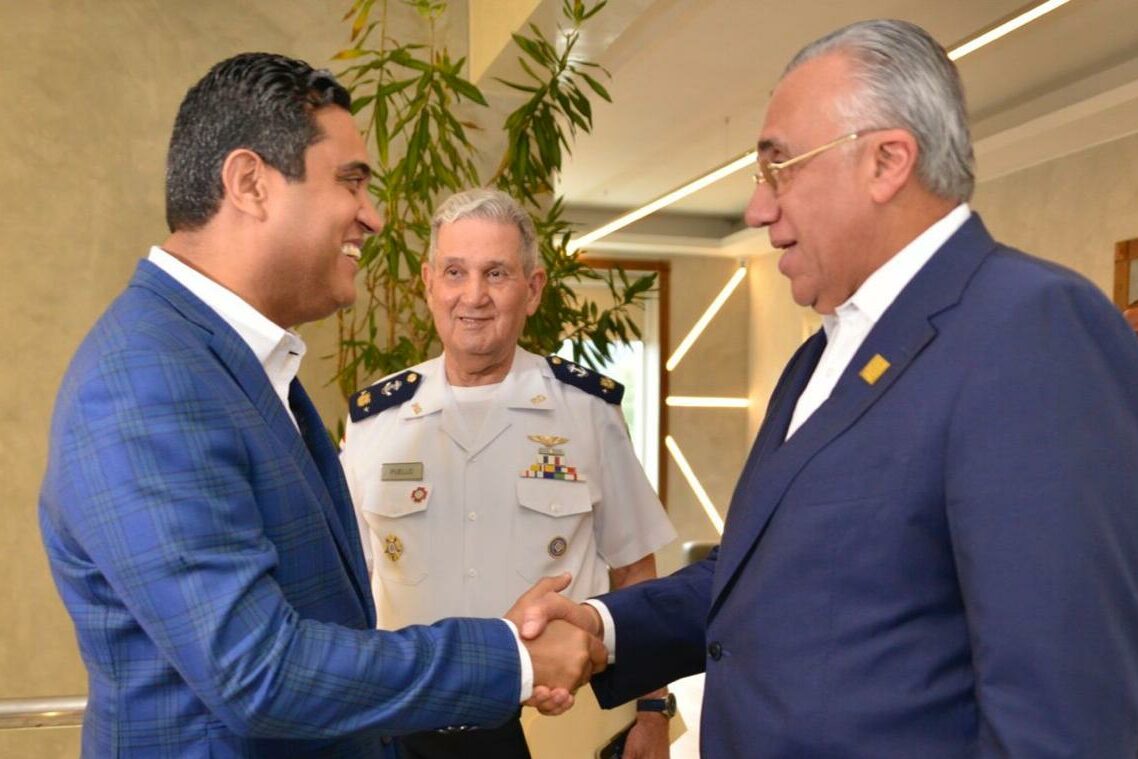 El ministro Kelvin Cruz mientras saluda al presidente de Centro Caribe Sports, Luis Mejía Oviedo y observa el presidente Ad Vitam del Comité Olímpico Dominicano, doctor José Joaquín Puello Herrera. (Cristina Liriano)